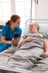 Obraz premium Female caretaker in nursing home talking with old woman