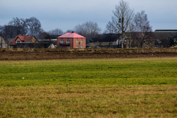 Obraz premium Village house , barns and fild . Late autumn in Europe after harvesting.