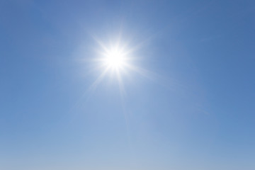 Naklejka na ściany i meble hot sparkle sun on a blue sky, outdoor summer sky background