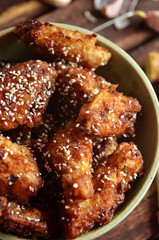 Korean chicken wings sprinkled with sesame in a rustic bowl