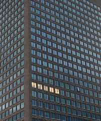 Hochhaus in der Dämmerung mit 5 beleuchteten Fenster
