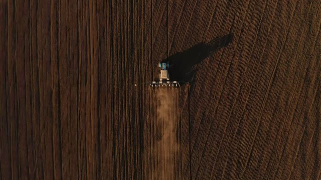 Harvester working in the field at spring and plowing the field