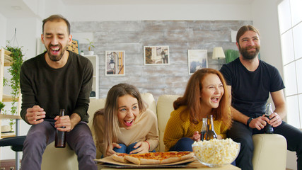 Group of friends sitting on couch using their smartphones