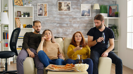 Man reaching for his beer while watching tv