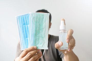 Man Holding face mask and spray alcohol, Alcohol for disinfecting Hands that touch the surface or at risk of infection, Mask wear for prevent infection against coronavirus or virus for airborne