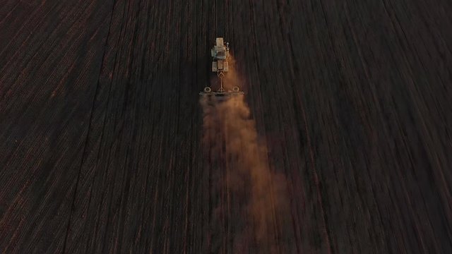 Harvester working in the field at spring and plowing the field