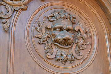 Decorative element of the wood door with lion head.