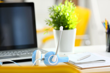 Empty remote office workplace with laptop pc and headset closeup. Receptionist or secretary of...