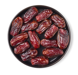 Dates on a black plate, isolated on white, from above