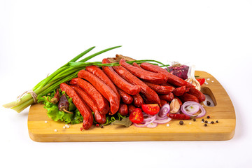 
sausage on a cutting board with herbs and vegetables white background