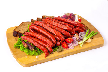 
sausage on a cutting board with herbs and vegetables white background