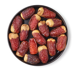 Dates on a black plate, isolated on white, from above