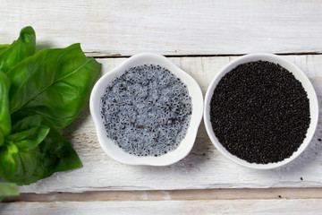 soaked with water basil seeds, green leaves and dry tukmaria in bowl on white wooden background