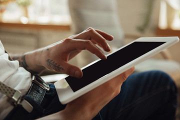 Close up of male hands using tablet with blank screen, copyspace. Surfing, online shopping, scrolling, betting, working. Education, freelance, art and business concept. Watching cinema, reading book.