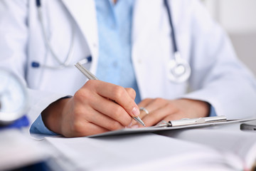 Female doctor arm hold silver pen and pad during ward round check closeup. Medic exam aid visit and remedy prescribe for sick office business visitor with problem and complaint for anamnesis concept