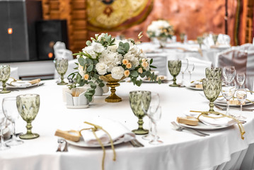 White wedding decoration in restaurant. Luxury wedding arrangement. Wedding banquet decoration. Tables in restaurant decorated with beautiful white peonies and roses