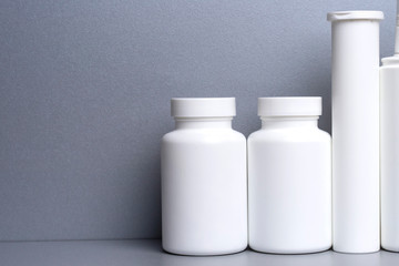 Set of plastic jars for drugs and vitamins on a gray background.