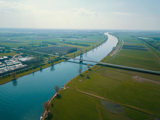 Aerial drone shot over the canal with bridge and road in the Netherlands