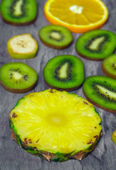 Fototapeta na wymiar Cut and sliced fruits - pineapple, kiwi, orange, banana. View from above
