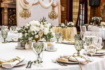 White wedding decoration in restaurant. Luxury wedding arrangement. Wedding banquet decoration. Tables in restaurant decorated with beautiful white peonies and roses