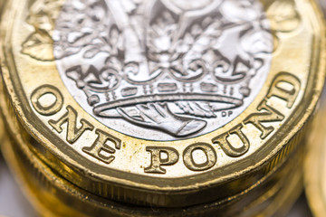 Close up view of the bottom edge of a British one pound coin. The Great British Pound sterling GBP