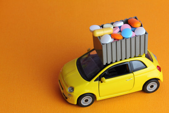 Medical preparations  courier service delivery.  A yellow toy car  with container of pills and  drugs.