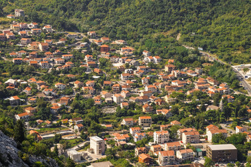 Red roofs of houses and buildings, village near Kotor in Montenegro, aerial view.