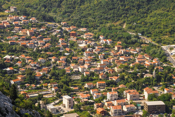 Fototapeta premium Red roofs of houses and buildings, village near Kotor in Montenegro, aerial view.