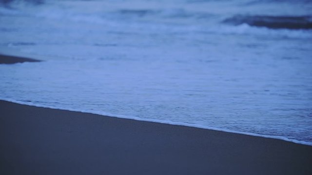 Waves crashing on Santa Severa sandy beach, at twilight
