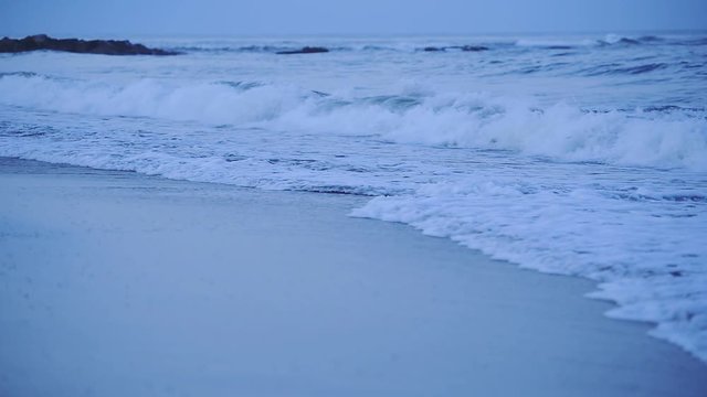 Sea waves crashing on Santa Severa beach, at twilight, Italy