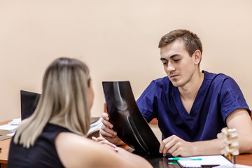 consultation of traumatologist. Portrait of doctor examining radiogram picture. Smiling physician pleased with results of treatment. Medicine and health care concept