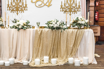 White wedding bouquet on the table in restaurant. Wedding banquet decoration. Tables in restaurant decorated with beautiful white peonies and roses