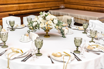 White wedding decoration in restaurant. Luxury wedding arrangement. Wedding banquet decoration. Tables in restaurant decorated with beautiful white peonies and roses