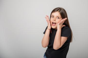 little girl is surprised on a white background, empty space