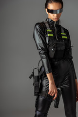 attractive futuristic african american woman in glasses with gun on grey © LIGHTFIELD STUDIOS