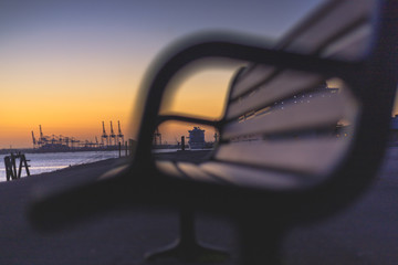 A shot of a large cruise liner in the distance, observed through the park bench