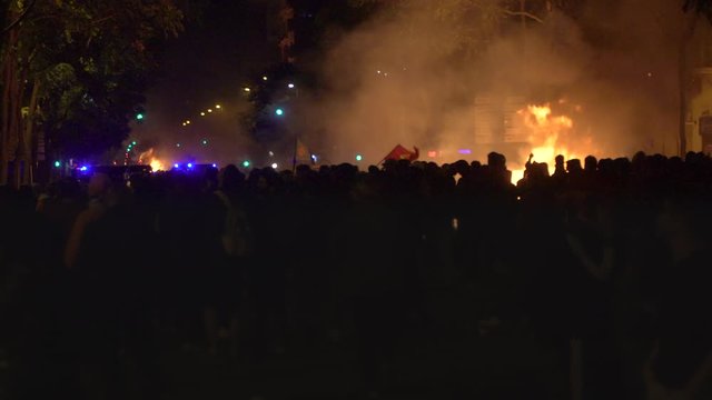 Riots and of people burning the streets of an European city at night (Barcelona, Spain)
