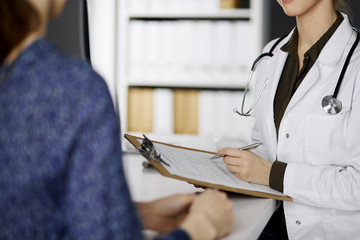 Doctor and patient discussing current health examination while sitting in clinic. Perfect medical...