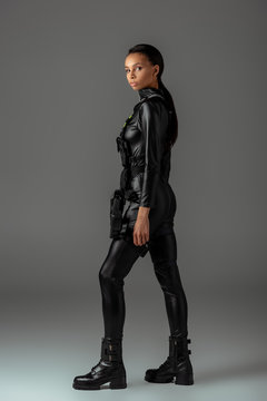 side view of young attractive futuristic african american woman on grey