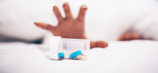 Obraz na płótnie Canvas hand holding a pills bottle. Medicine pills. Background. Bed. Drugs. 