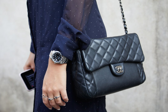 Woman with black Chanel leather bag and Rolex Datejust watch with black dial on September 20, 2018 in Milan, Italy