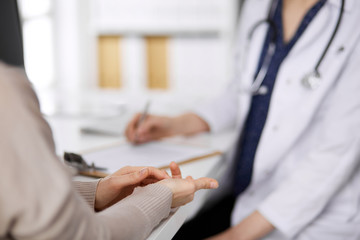 Doctor and patient discussing current health examination while sitting in clinic. Perfect medical...