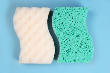 Two bath sponges on a blue background
