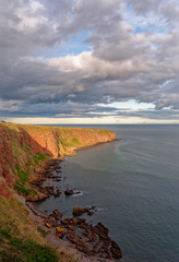 Looking across the shingle and Rocky beach of Carlingheugh Bay towards the headland before the Fishing Village of Auchmithie.