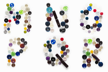 Miscellaneous colored buttons from clothes in the form of letters