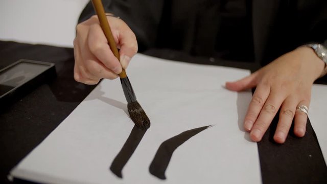  woman writing Japanese calligraphy