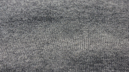 Creased gray woven fabric texture. Wavy grey textile, rough thread canvas clothes, warm jacket or hoodie material background. Fashion clothes design, simple classic grey color shirt detailed view