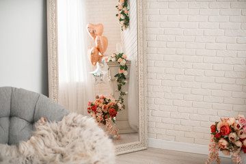 large mirror in a beautiful frame, reflection fireplace decorated with flowers