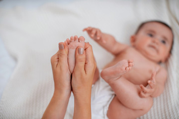 Close-up of children's foot massage on the bed.