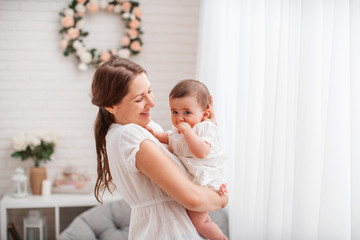 Happy loving family. A young mother plays with her child in the bedroom.